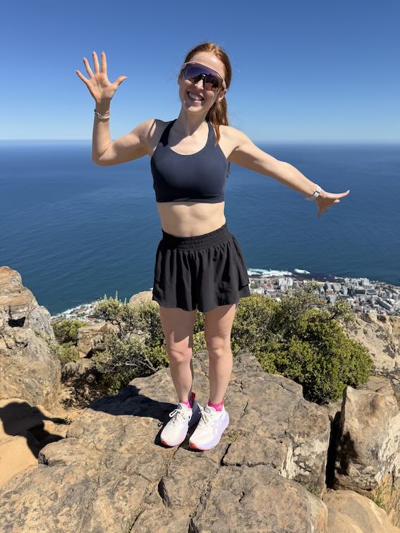 Hannah in a sports bra at the top of the mountain