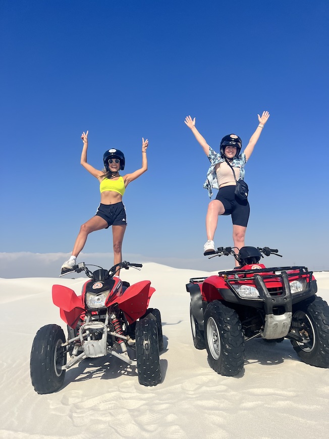 Hannah and Sophie on quad bikes with their hands up