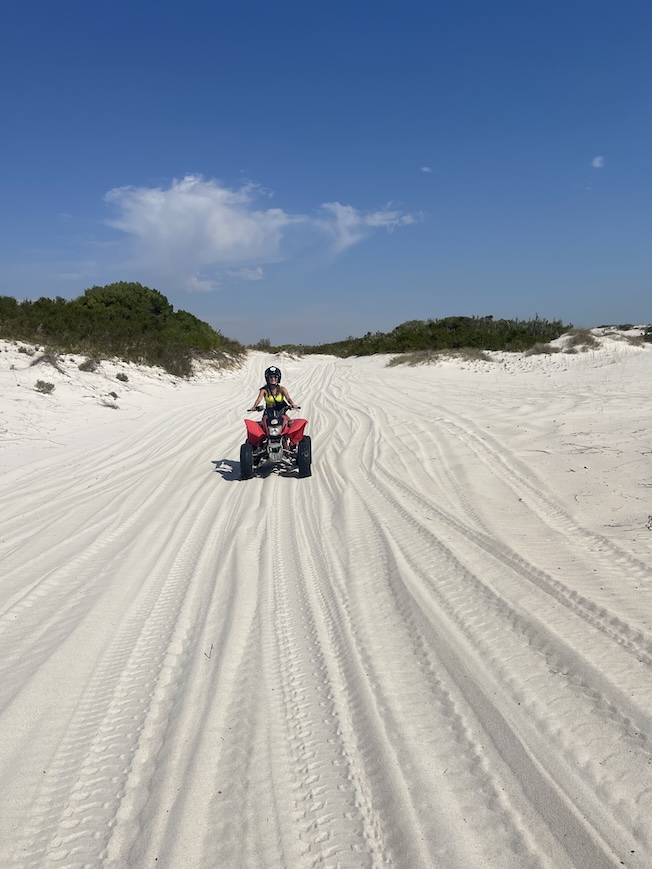 Sophie riding an ATV on the Atlantis dunes