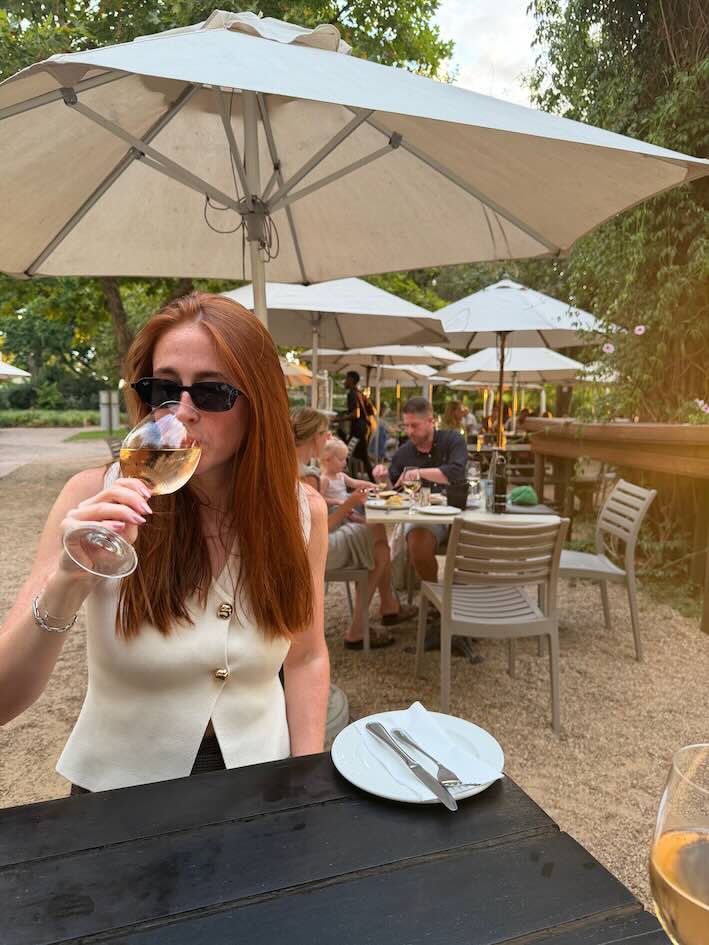 Hannah sipping wine at Eikendal