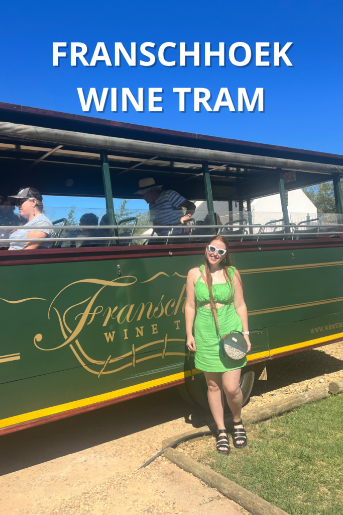 Photo of Hannah in front of Franschhoek wine tram with text reading "Franschhoek Wine Tram"